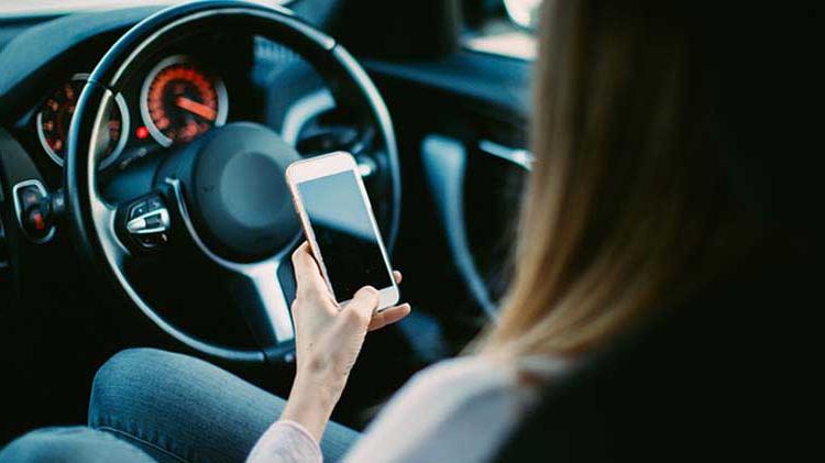 Woman driving distracted with cell phone