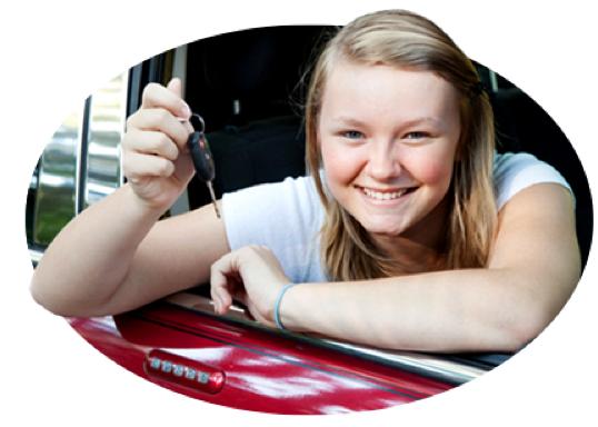 A smiling teen holds up the car keys as a good student reward.